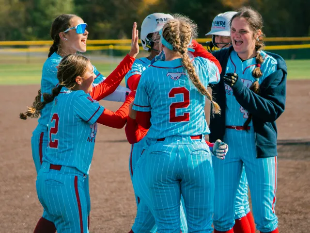Softball athletes celebrating together at a Connect Sports event