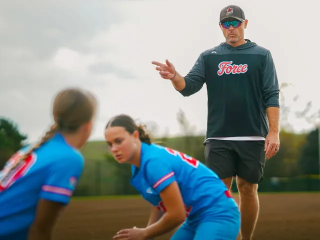 College coach working with softball athletes